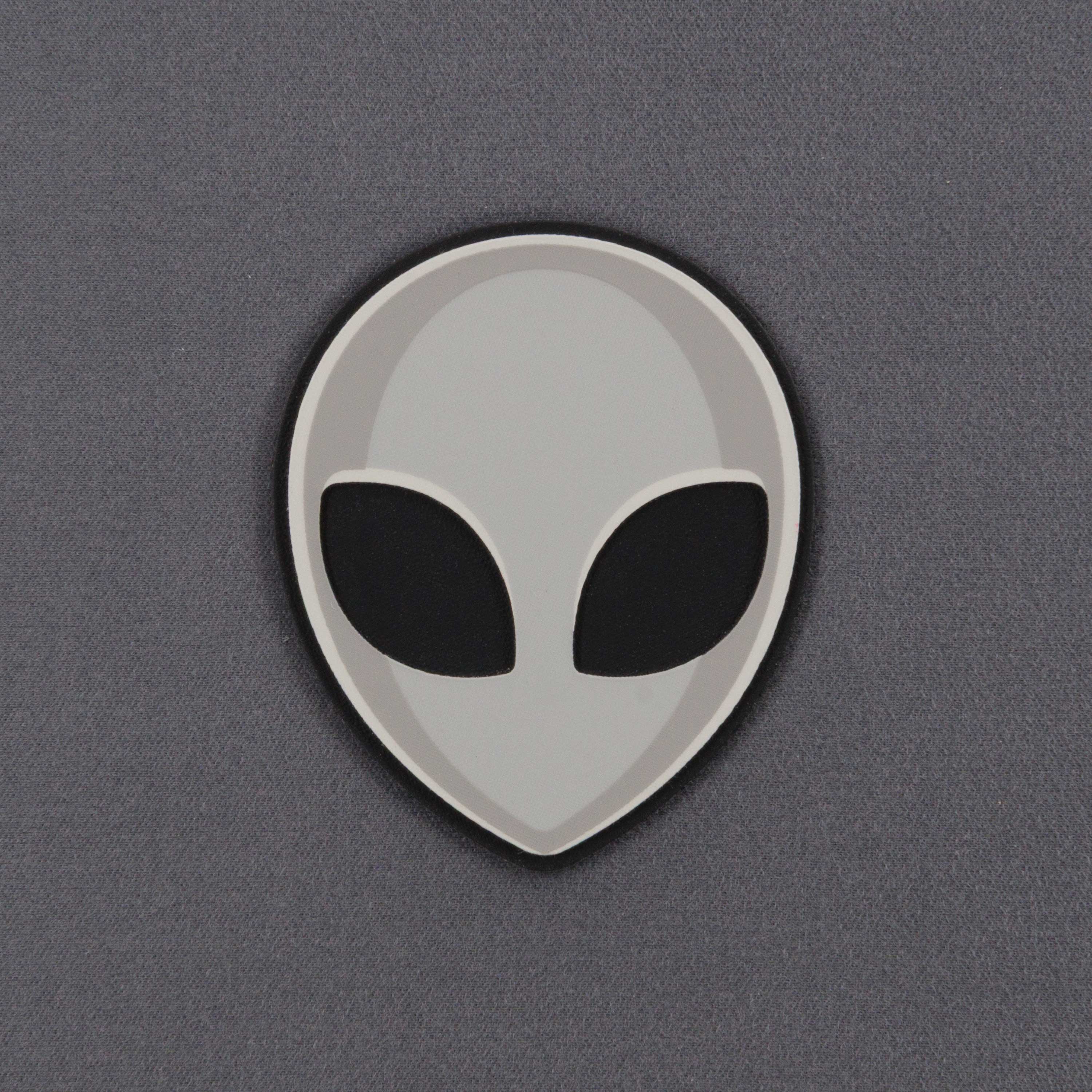 The Alien Gray (Double Layer Silicone) Flexfit® Mesh Trucker Cap by Eternal Glyph features a minimalistic grey alien head icon with black oval eyes on a smooth, light gray background, inspired by classic UFO pop culture.