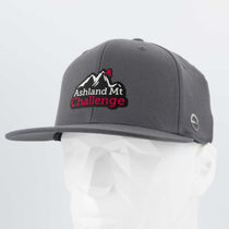 A grey Eternal Glyph Flexfit 110® Flat Bill Snapback Cap sits on a mannequin, featuring the Ashland Mt. Challenge double layer silicone logo, celebrating the iconic Pacific Northwest mountain bike race.