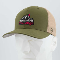 The Eternal Glyph Ashland Mt. Challenge (Double Layer Silicone) Flexfit 110® mesh trucker cap features a green and beige design with an embroidered mountain logo and event text, shown on a white mannequin head.