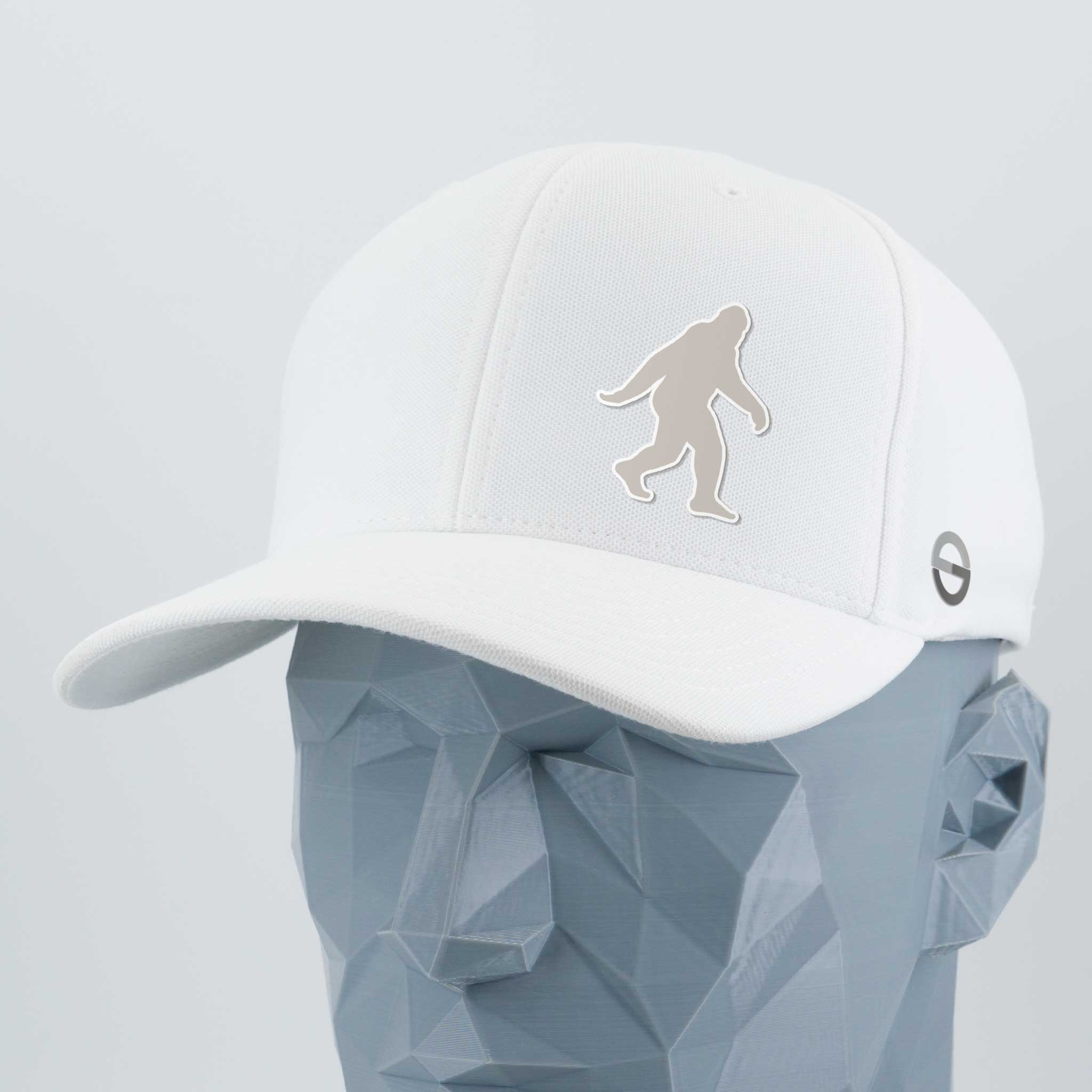 The Eternal Glyph Bigfoot Silhouette Albino Flexfit® Cool & Dry Cap features a bold Bigfoot design on white silicone, shown on a faceted gray mannequin. A small circular logo adds Pacific Northwest flair to this unique accessory.