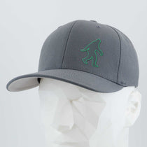 The Eternal Glyph Bigfoot Silhouette (Silicone) Flexfit® Premium Wool Blend Cap in gray, featuring a green Bigfoot design on the front, brings an adventurous icon to your everyday style. Displayed on a white faceted mannequin head.