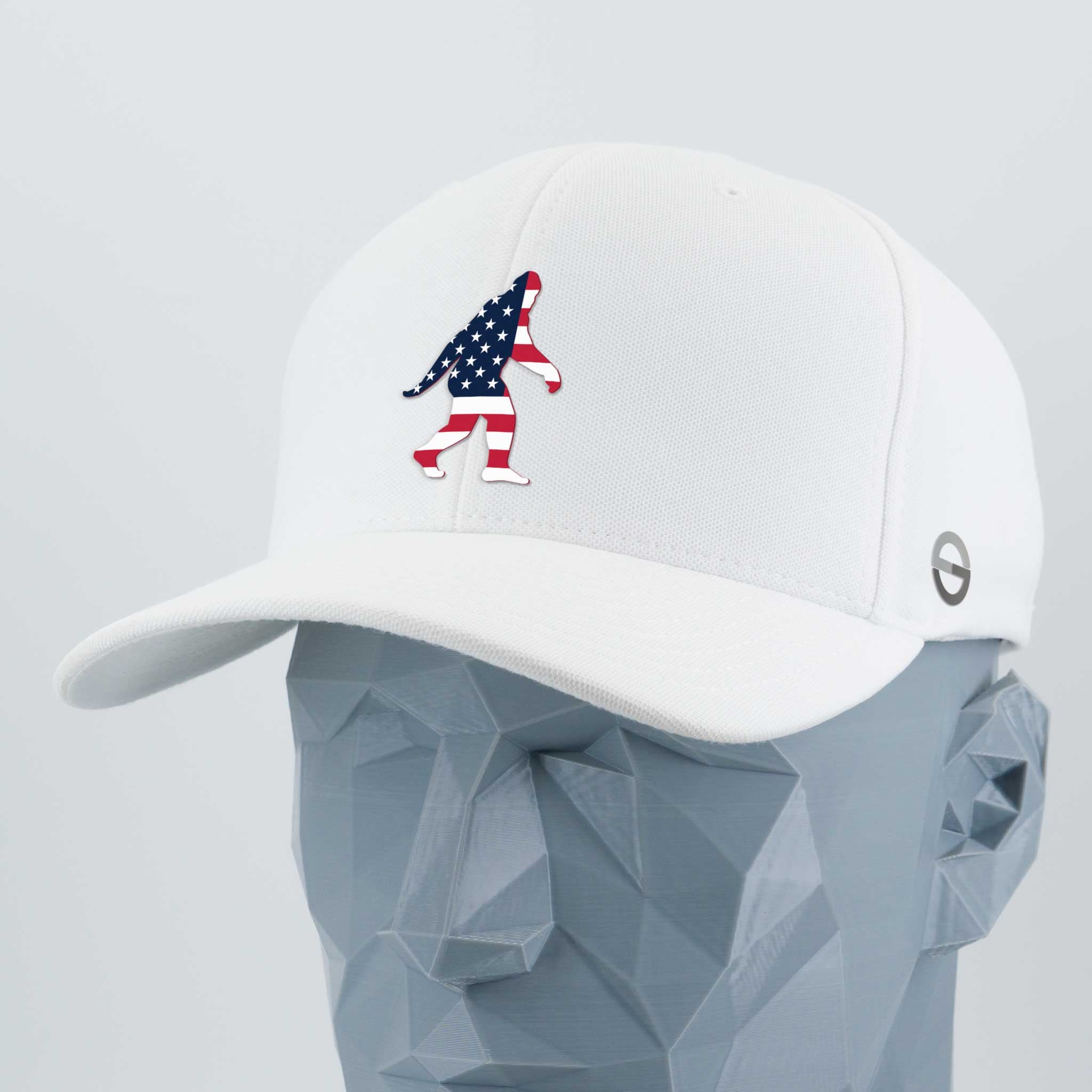 The Eternal Glyph Patriotic Bigfoot (Silicone) Flexfit® Cool & Dry Cap is a white hat with an American flag Bigfoot silhouette on the front, showcased on a faceted gray mannequin head.