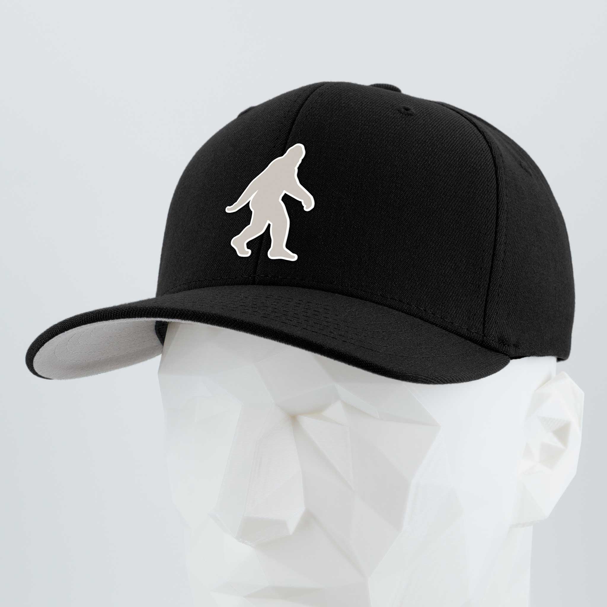 The Eternal Glyph Bigfoot Silhouette Albino Flexfit® Premium Wool Blend Cap in black features a white Sasquatch glyph on the front, blending Pacific Northwest folklore with modern style.