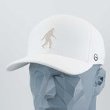 The Eternal Glyph Bigfoot Silhouette Albino (Silicone) Flexfit® Cool & Dry Cap in white is shown on a gray polygonal mannequin head, featuring a bold Bigfoot design inspired by Pacific Northwest folklore.