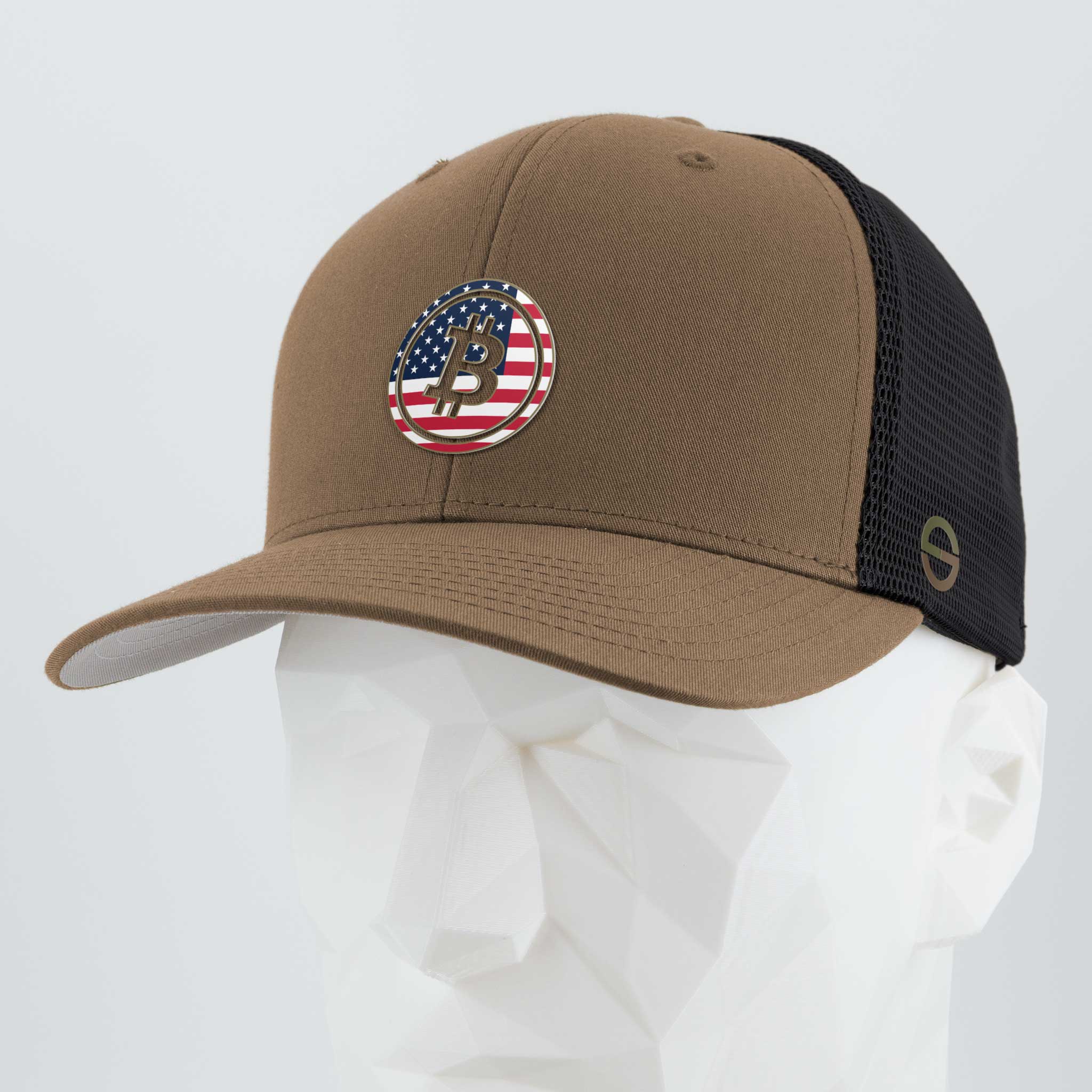 The Eternal Glyph Bitcoin U.S.A. (Silicone) Flexfit® Mesh Trucker Cap in Coyote/Black features a round patch with the Bitcoin U.S.A. glyph over an American flag, shown on a white geometric mannequin head.