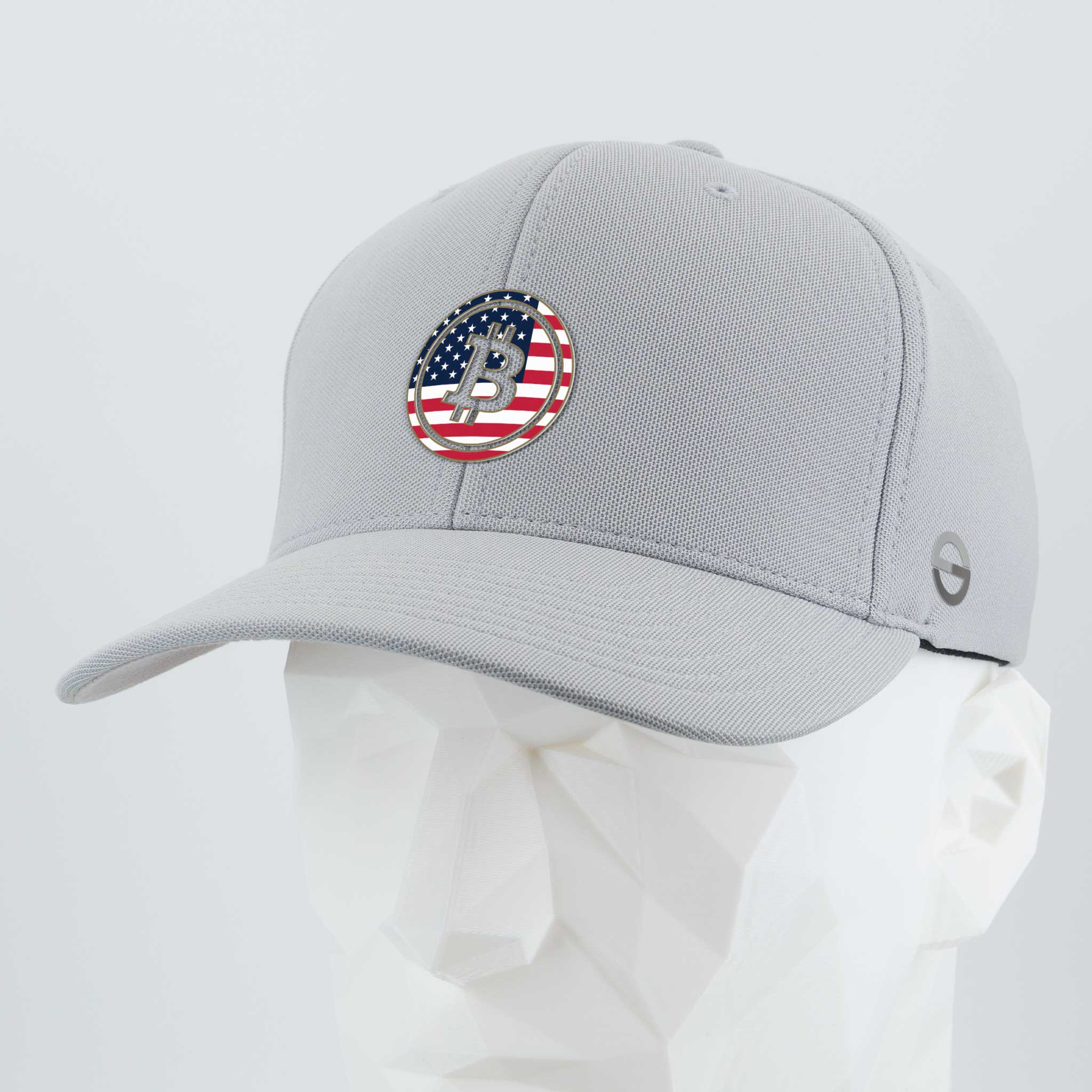 The Eternal Glyph Bitcoin U.S.A. (Silicone) Flexfit® Cool & Dry Cap is a light gray hat with a circular patch showing a stylized Bitcoin B over the American flag, displayed on a white geometric mannequin head.