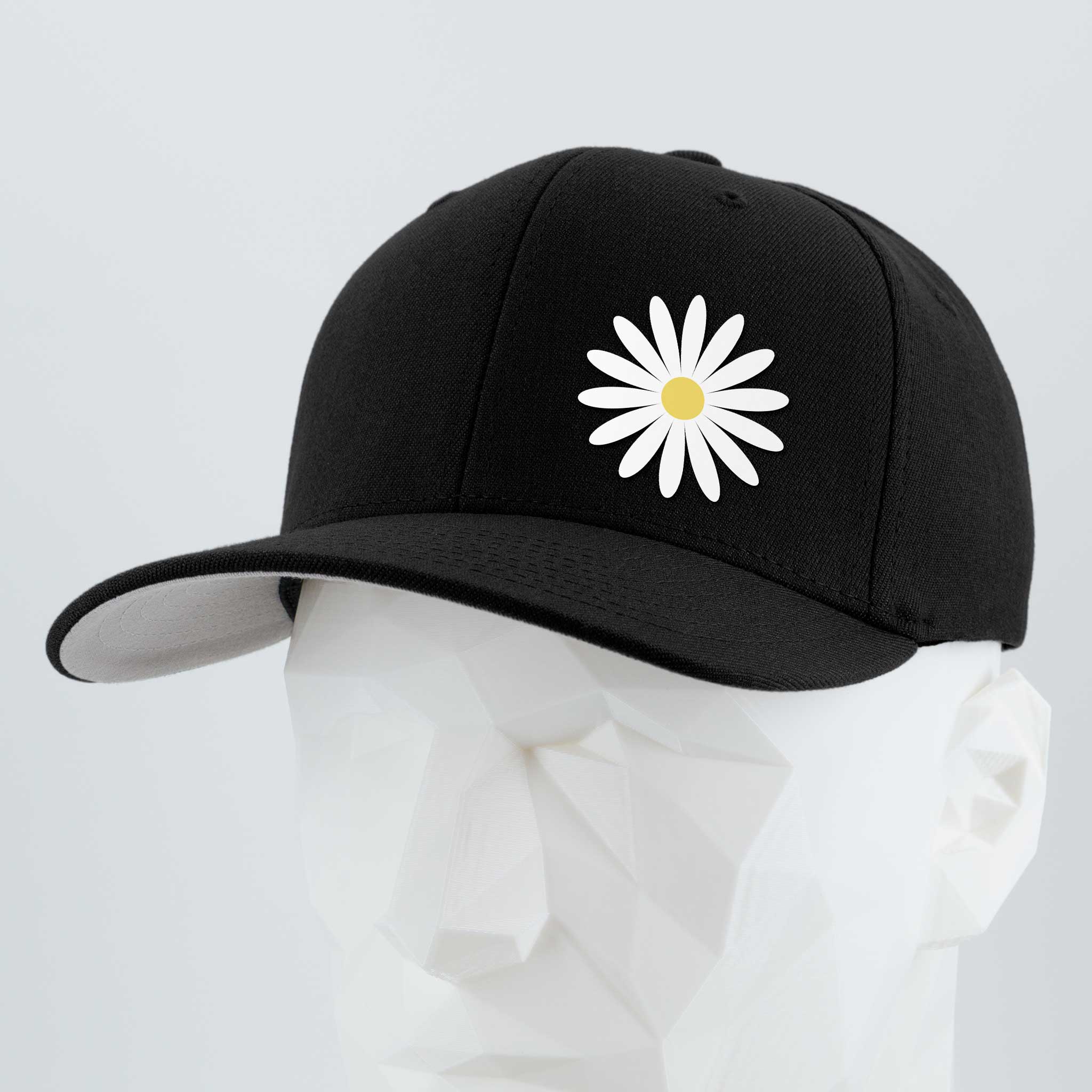 The Daisy (Silicone) - Flexfit® Premium Wool Blend Cap by Eternal Glyph, shown in black with a white flower and yellow center, is displayed on a white geometric mannequin head against a light gray background—timeless optimism in style.
