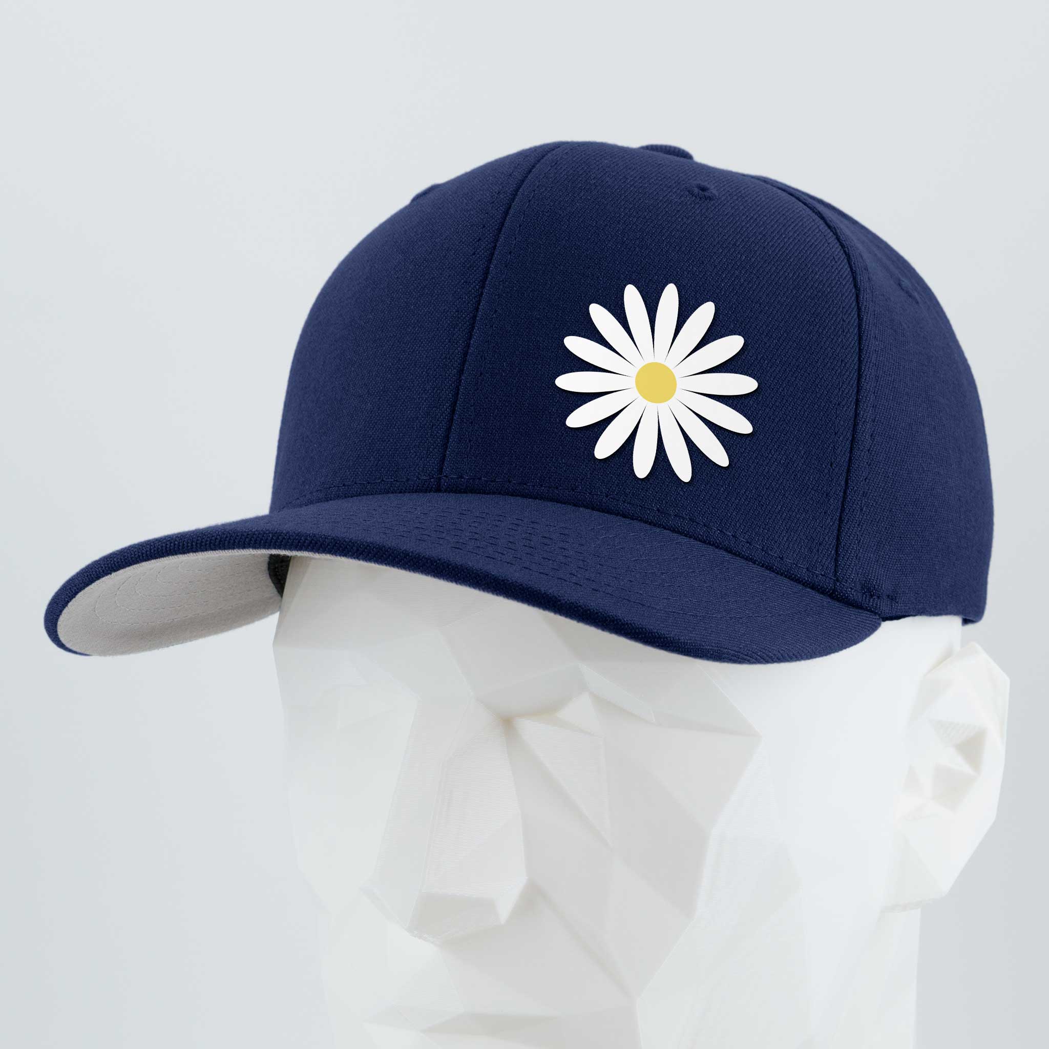 The Daisy (Silicone) - Flexfit® Premium Wool Blend Cap by Eternal Glyph in navy blue features a white daisy with yellow center embroidery on the front, shown on a white geometric mannequin head—an everyday symbol of optimism.