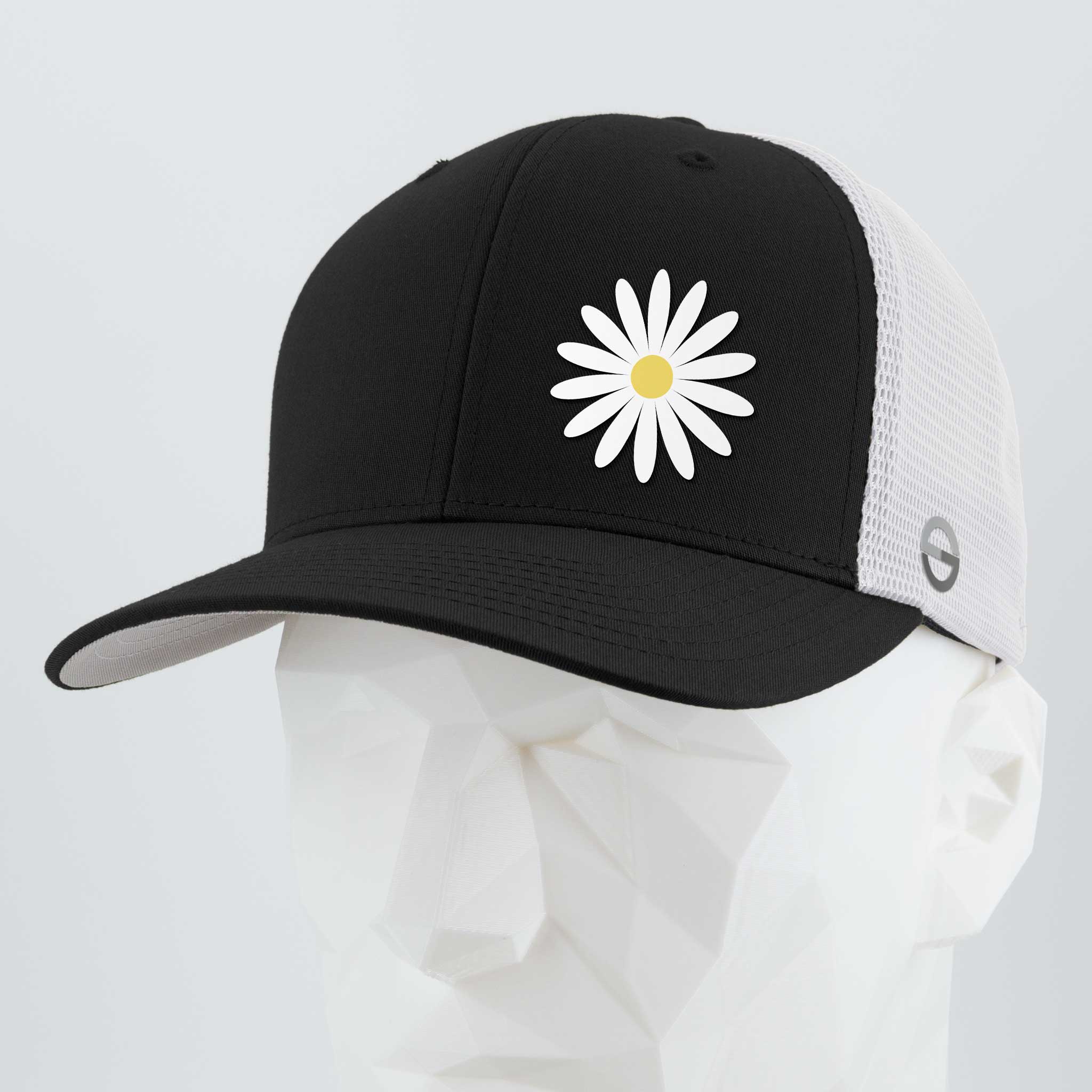 The Daisy (Silicone) - Flexfit® Mesh Trucker Cap by Eternal Glyph features a black and white mesh design with a silicone daisy patch—an optimistic touch, shown on a white geometric mannequin head. Ideal for everyday wear.