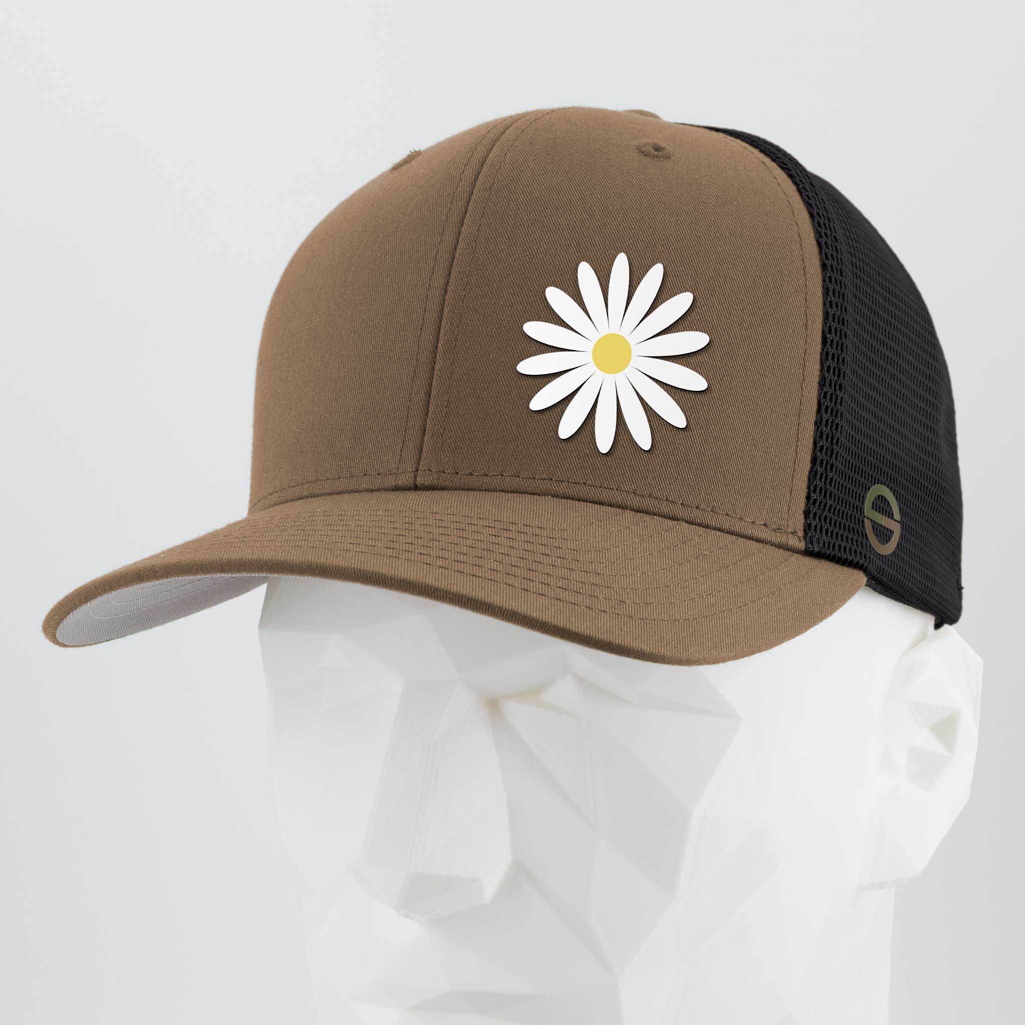 The Daisy (Silicone) - Flexfit® Mesh Trucker Cap by Eternal Glyph features a brown and black design with a white daisy and yellow center—an everyday hat symbolizing optimism, shown on a white mannequin head against a light gray background.