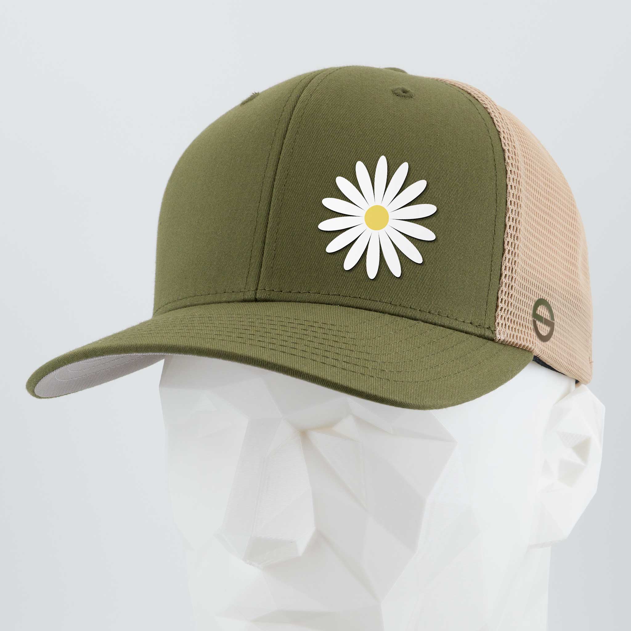 The Daisy (Silicone) - Flexfit® Mesh Trucker Cap by Eternal Glyph in olive green and beige features a white daisy with a yellow center—an optimistic touch for your everyday hat collection. Displayed on a white geometric mannequin head.