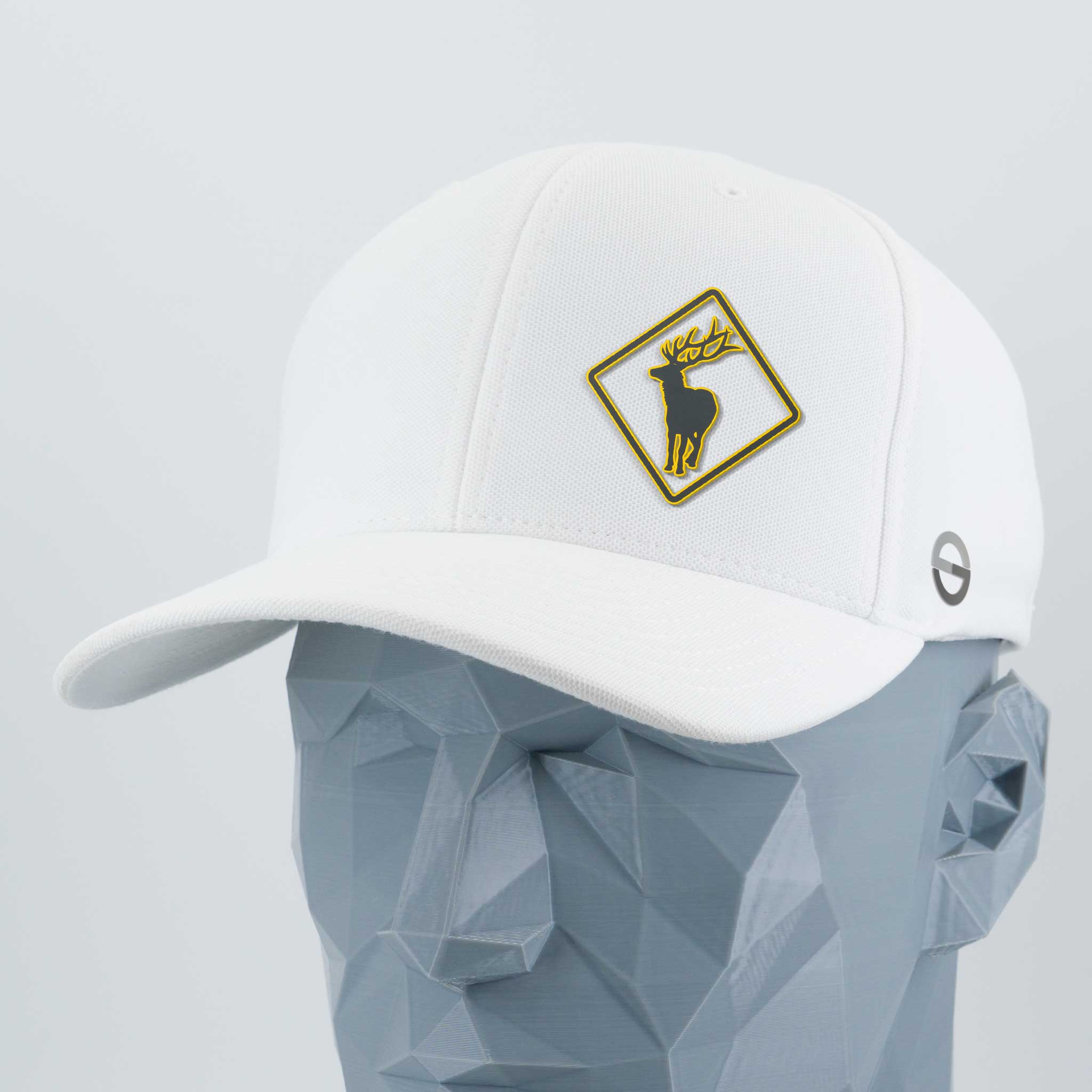 The Eternal Glyph Elk Crossing Sign (Silicone) - Flexfit® Cool & Dry Cap, a white hat with a gold-trimmed diamond patch featuring a black deer head, is shown on a geometric gray mannequin head.