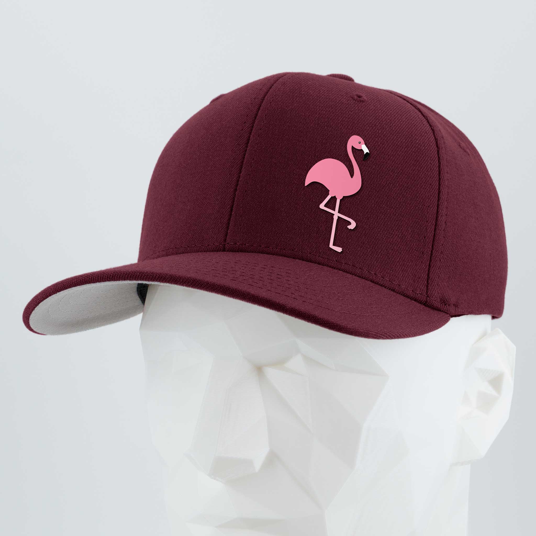 The Eternal Glyph Pink Flamingo (Silicone) Flexfit® Premium Wool Blend Cap in burgundy features a Pink Flamingo glyph embroidered on the front, shown on a white geometric mannequin head against a light gray background.