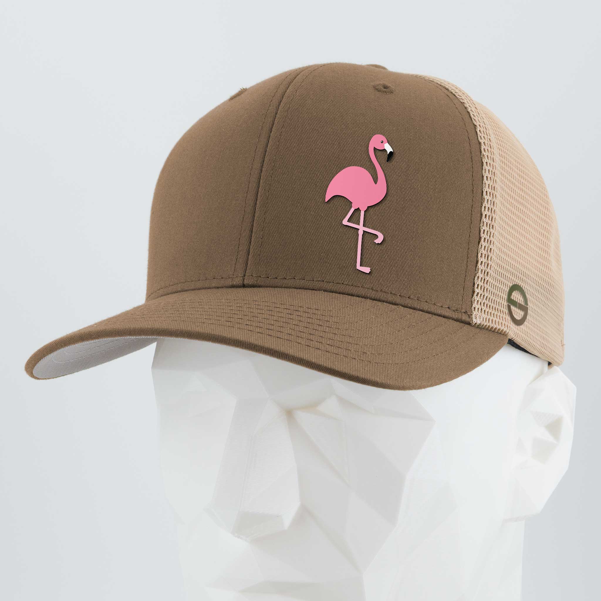 The Eternal Glyph Pink Flamingo (Silicone) Flexfit® Mesh Trucker Cap in Coyote/Khaki features a pink flamingo design on the front and is shown on a white geometric mannequin head, giving off retro lawn flamingos vibes.