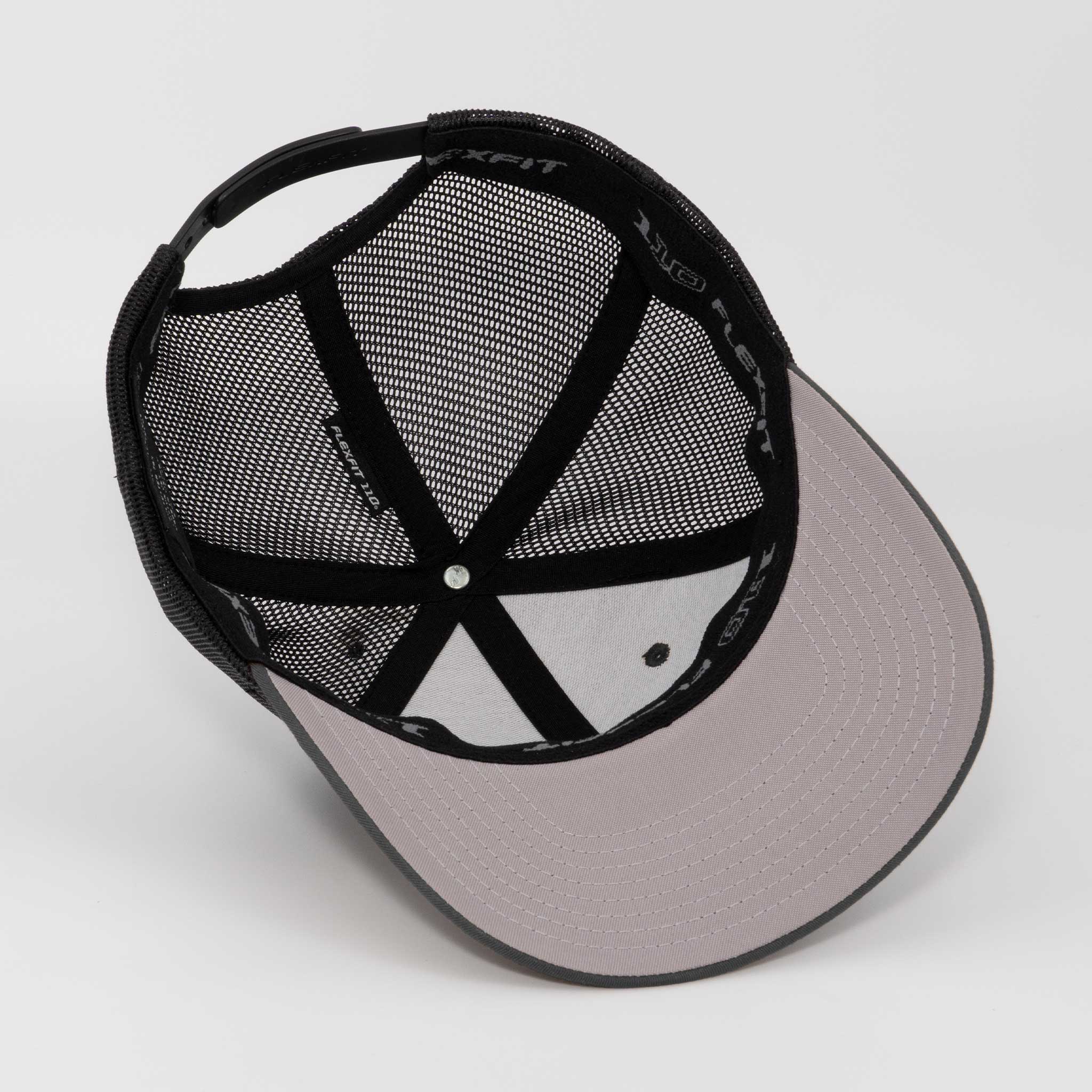 The Eternal Glyph Hiker Trail Sign (Silicone) Flexfit® Mesh Trucker Cap is shown upside down, revealing its gray and black mesh, adjustable snapback, stitched panels, and a light gray brim—ideal for outdoor adventures.