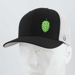 The Eternal Glyph Hop Cone (Silicone) - Flexfit® Mesh Trucker Cap features a black and white design, breathable mesh back, and a green Hop Cone Symbol up front—ideal for beer enthusiasts. Shown on a white geometric mannequin head.