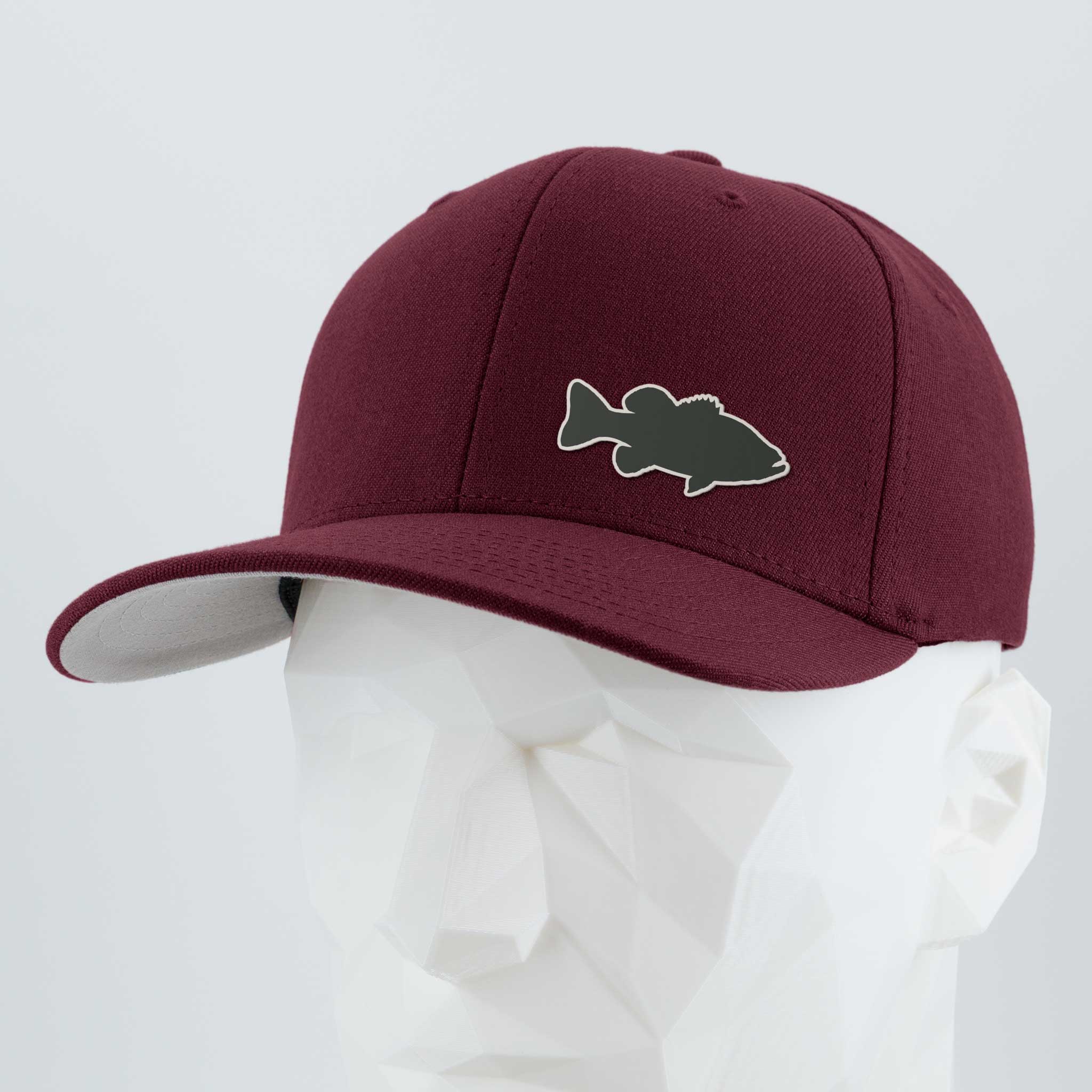 The Eternal Glyph Large Mouth Bass Fishing (Silicone) Flexfit® Premium Wool Blend Cap in maroon features a gray bass-shaped patch on the front, shown on a white geometric mannequin head against a light gray background.