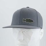The Eternal Glyph Large Mouth Bass (Silicone) Flexfit® Flat Bill Premium Fitted Cap in gray features a black bass fishing silhouette patch on the front, shown on a white geometric mannequin head.