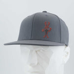 The Eternal Glyph Moab Man Petroglyph (Silicone) Flexfit® Flat Bill Premium Fitted Cap in dark gray features a red line drawing inspired by the Moab Man petroglyph on the front, shown on a white geometric mannequin head.