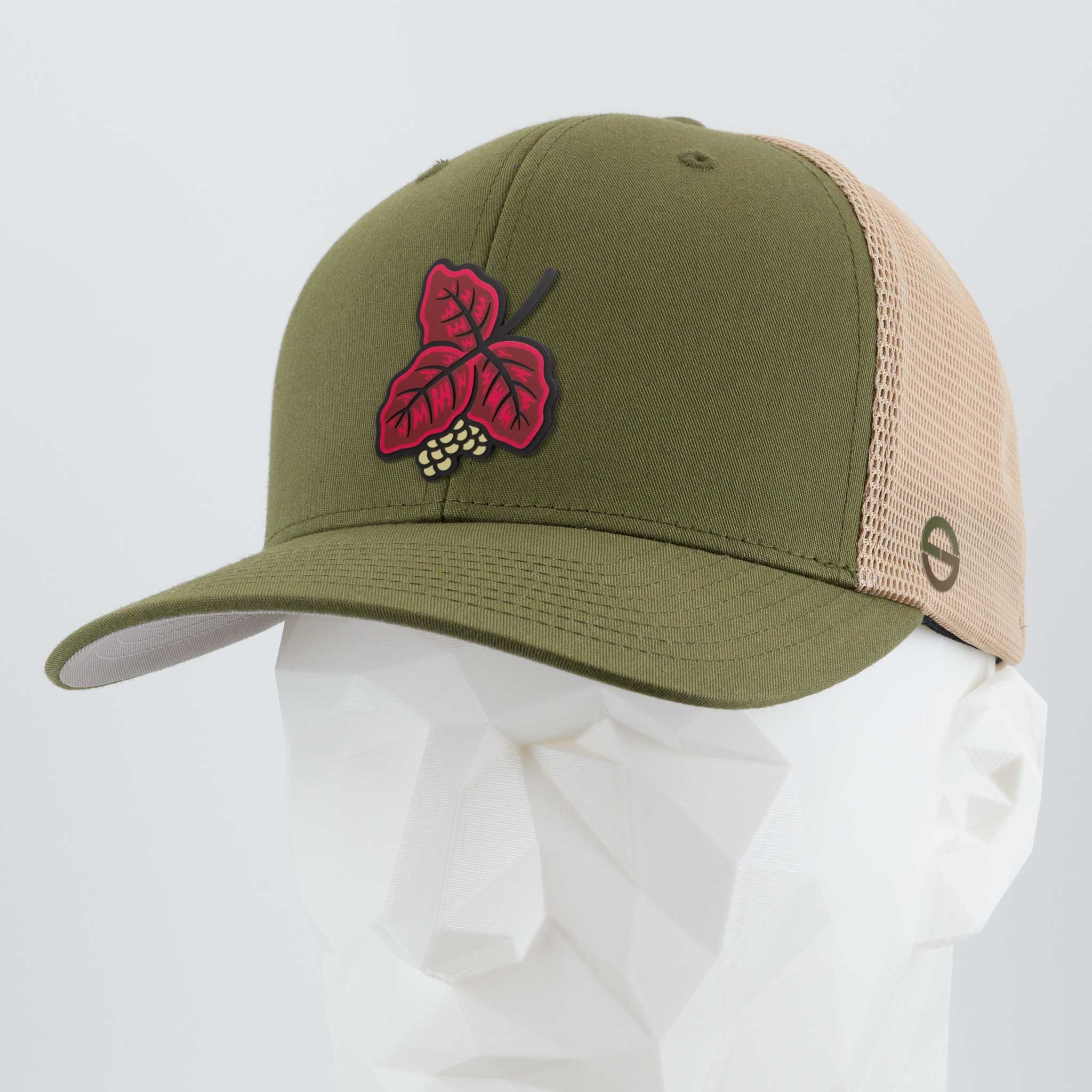 An Eternal Glyph Poison Oak (Double Layer Silicone) Flexfit® Mesh Trucker Cap in Olive/Khaki, shown on a white geometric mannequin, features front embroidery of a red maple leaf with acorns—a symbol of outdoor wisdom.