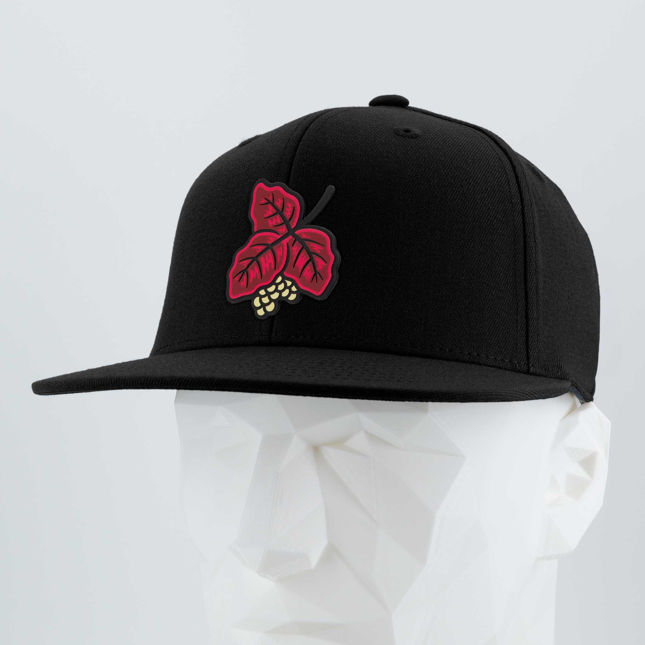 The Poison Oak (Double Layer Silicone) Flexfit® Flat Bill Premium Fitted Cap by Eternal Glyph is a black snapback, featuring an embroidered red grape leaf and yellow grapes on the front—ideal for outdoor adventurers.
