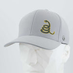 The Eternal Glyph Coiled Rattlesnake Silhouette (Silicone) Flexfit® Cool & Dry Cap is light gray with a yellow rattlesnake graphic, Gadsden flag-inspired, plus a small circular logo on the side, shown on a white faceted mannequin head.