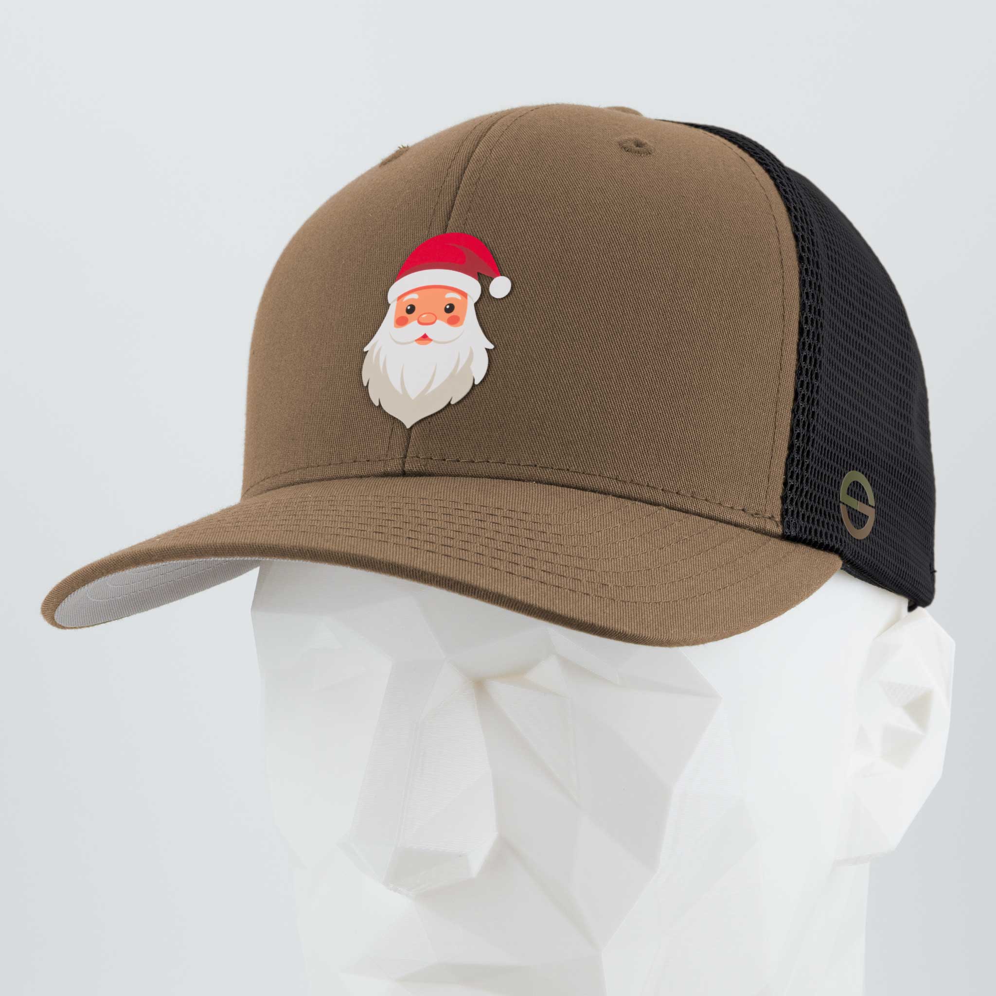 The Eternal Glyph Santa Hat (Silicone) - Flexfit® Mesh Trucker Cap in Coyote/Black features a Santa Claus glyph graphic on the front panel, shown on a white geometric mannequin head.