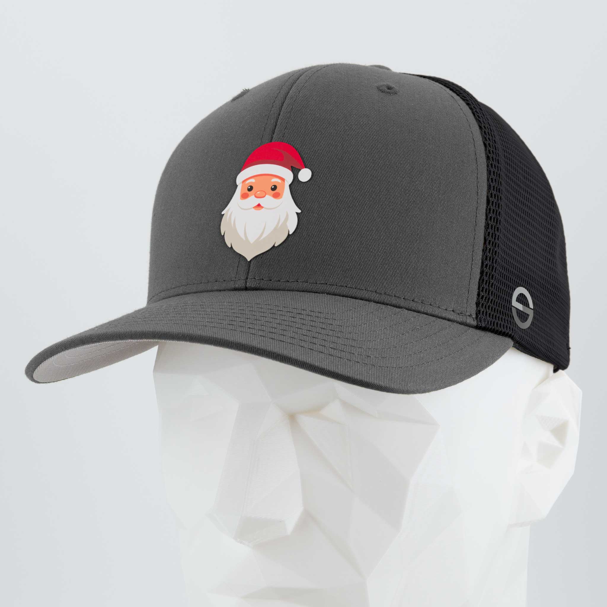 The Eternal Glyph Santa Hat (Silicone) Flexfit® Mesh Trucker Cap in dark gray/black features a cartoon Santa Claus with a red hat, adding playful Christmas style. Shown on a white geometric mannequin head.