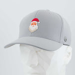 The Eternal Glyph Santa Hat (Silicone) - Flexfit® Cool & Dry Cap in silver features a small cartoon Santa face with a red hat—perfect for Christmas style. Displayed on a white geometric mannequin head.