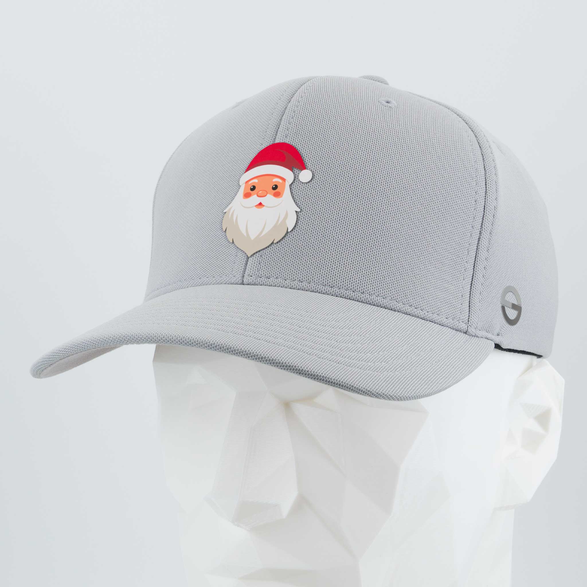 The Eternal Glyph Santa Hat (Silicone) - Flexfit® Cool & Dry Cap in silver features a small cartoon Santa face with a red hat—perfect for Christmas style. Displayed on a white geometric mannequin head.
