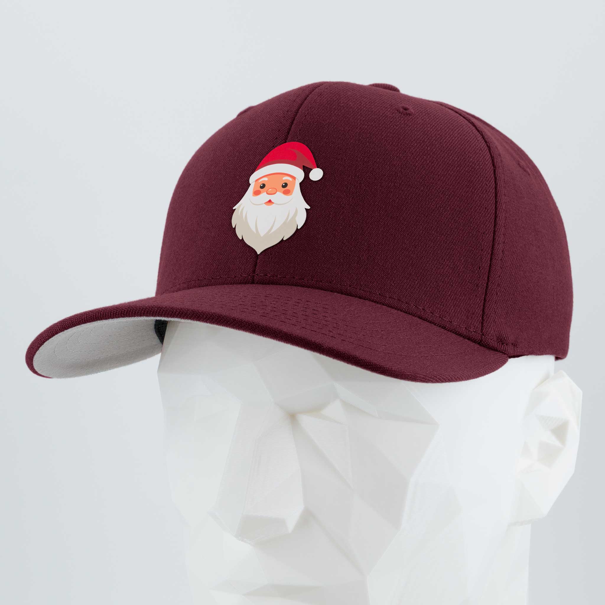 The Eternal Glyph Santa Hat (Silicone) Flexfit® Premium Wool Blend Cap in maroon showcases a cheerful Santa Claus face, displayed on a white geometric mannequin head against a plain background for festive holiday style.