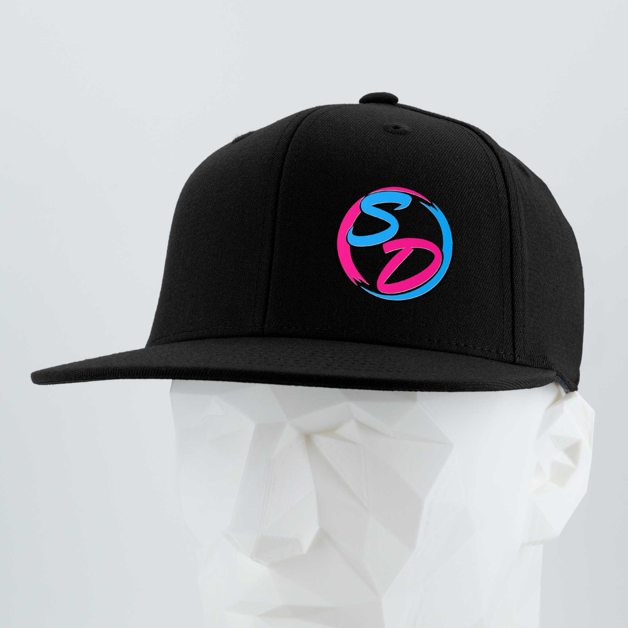 Showcased on a white, faceted mannequin head against a light gray background, the Eternal Glyph Staying Driven (Silicone) – Flexfit® Flat Bill Premium Fitted Cap features a sleek black design with a striking blue and pink SD logo on the front, making it the ideal fitness cap for any online crew or your everyday workout essential.