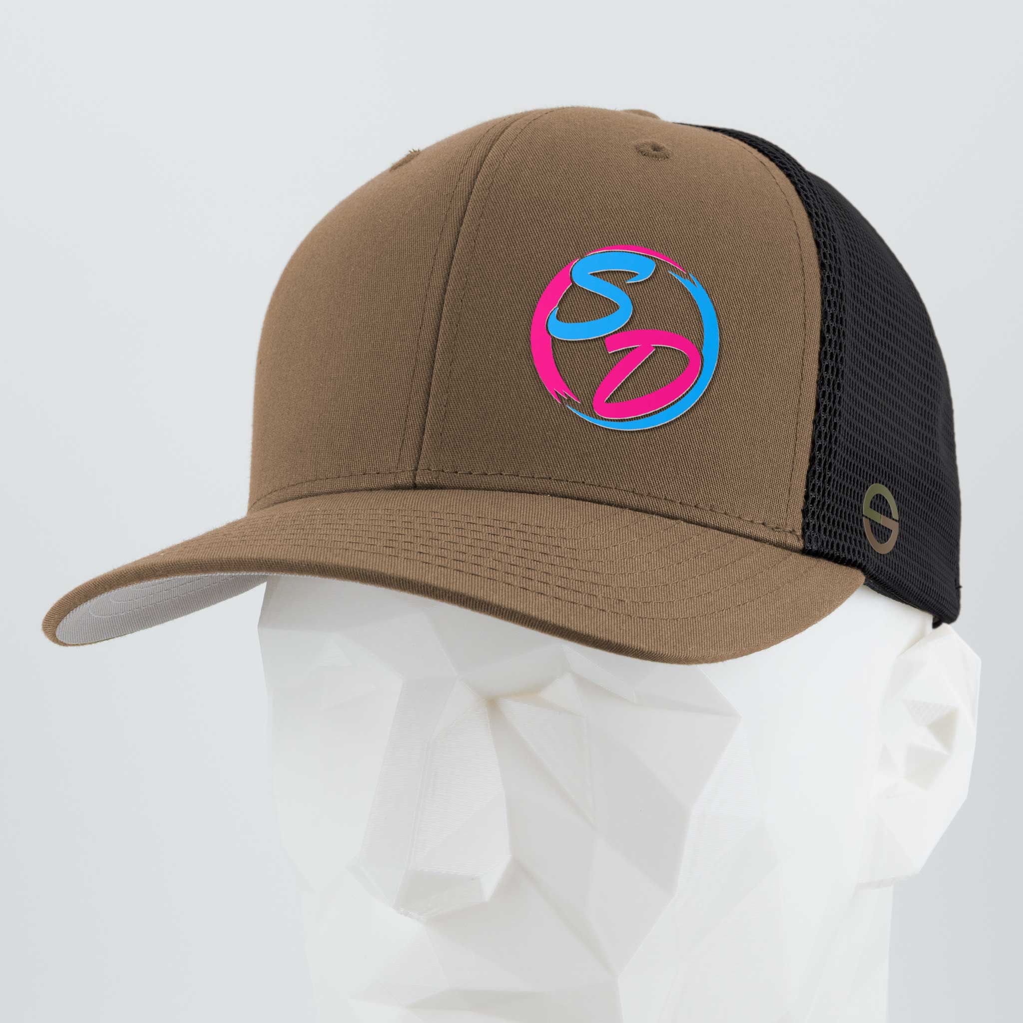 Introducing the Eternal Glyph Staying Driven (Silicone) - Flexfit® Mesh Trucker Cap in Coyote/Black, featuring a vibrant blue and pink SD logo on the front. Shown on a white geometric mannequin head, this premium hat is the perfect accessory for any online fitness crew wanting to stay stylish and motivated.