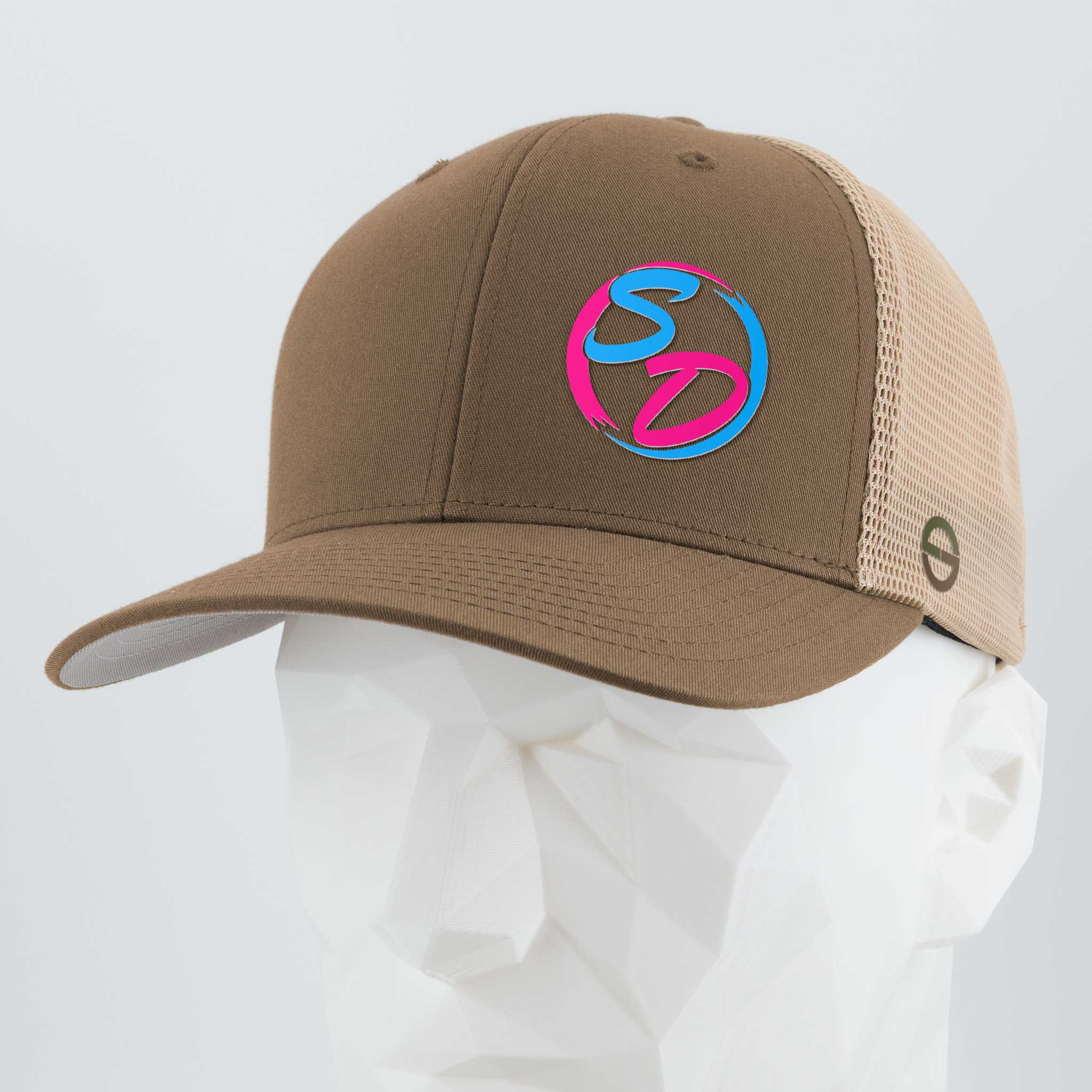 A Coyote/Khaki Flexfit® Mesh Trucker Cap from Eternal Glyph, the Staying Driven (Silicone) edition, displayed on a white geometric mannequin head and highlighted by a vibrant pink and blue SD logo on the front panel—this premium cap is ideal for any online fitness crew eager to represent their Staying Driven style with flair.