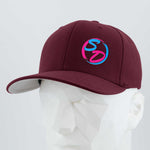 A faceted white mannequin wears the Eternal Glyph Staying Driven (Silicone) Flexfit® Premium Wool Blend Cap in maroon—premium headwear showcasing a vibrant SD logo in pink and blue on the front. Ideal for the Staying Driven fitness crew, set against a plain light gray background.