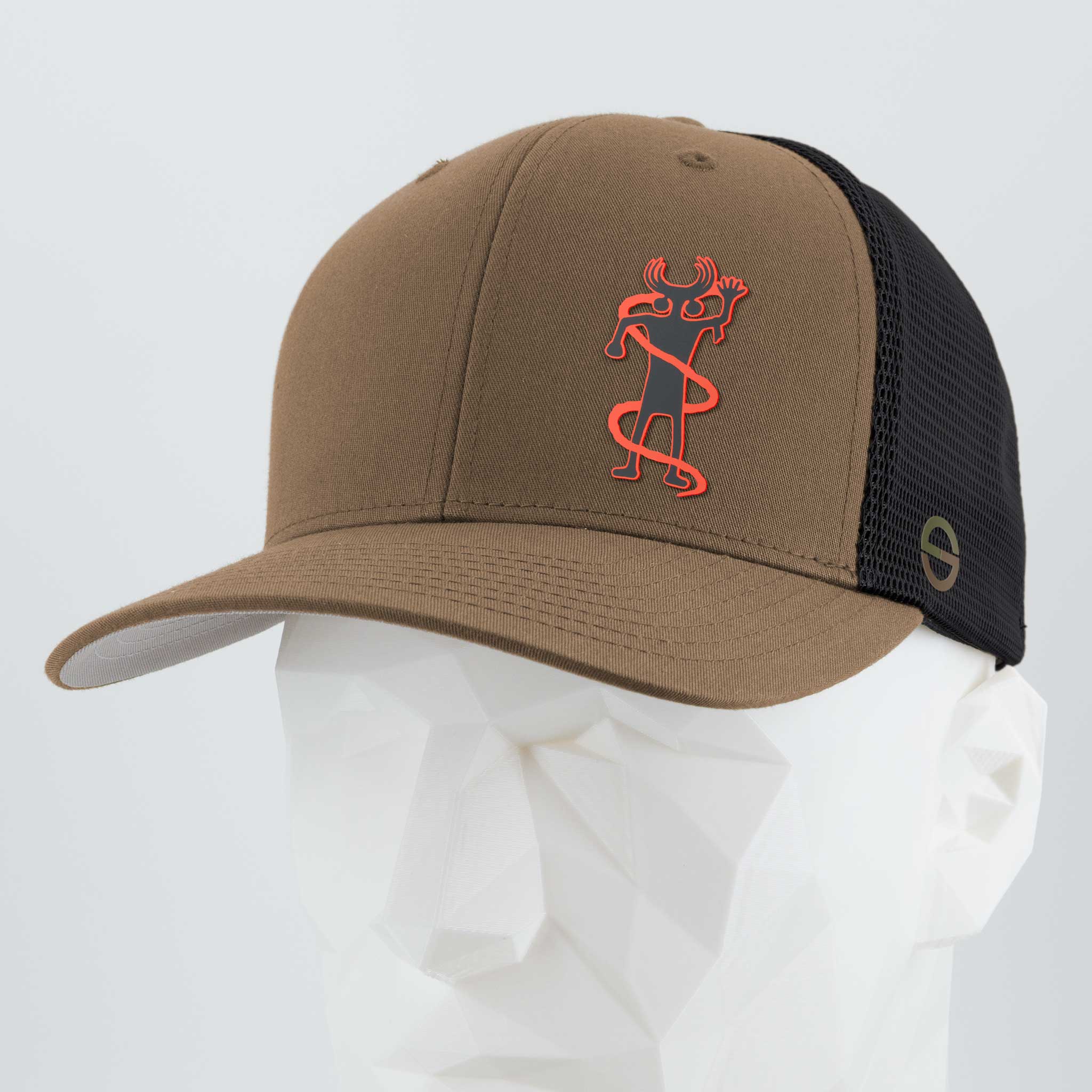 The Eternal Glyph Moab Shaman Petroglyph (Silicone) Flexfit® Mesh Trucker Cap features a brown and black design with an abstract red and black figure on the front, shown on a white geometric mannequin head.