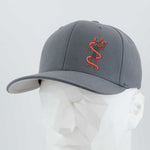 The Eternal Glyph Moab Shaman Petroglyph (Silicone) Flexfit® Premium Wool Blend Cap in dark gray features an orange stylized Moab Shaman design on the front and is displayed on a white geometric mannequin head.