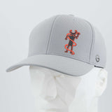 The Eternal Glyph Moab Shaman Petroglyph (Silicone) Flexfit® Cool & Dry Cap in silver, featuring a red and black Kokopelli design inspired by the Moab petroglyph, is shown on a white angular mannequin against a light gray background.