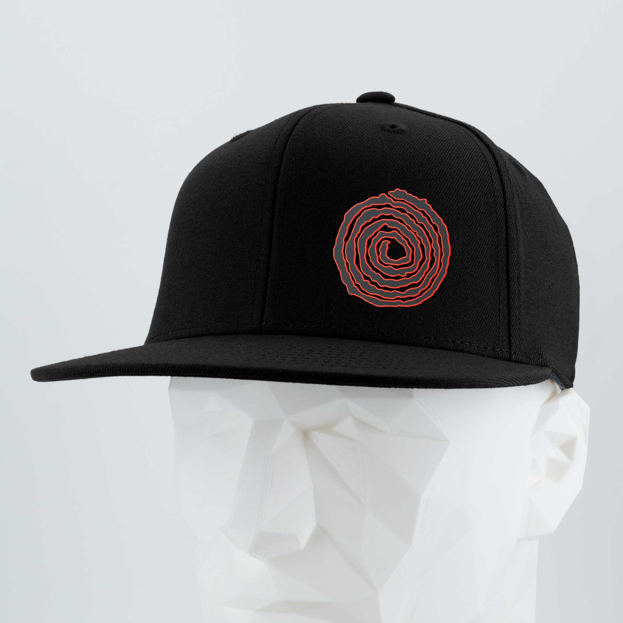 The Eternal Glyph Moab Spiral Petroglyph (Silicone) Flexfit® Flat Bill Premium Fitted Cap, a black snapback featuring a red spiral design, is shown on a white geometric mannequin head against a light gray background.
