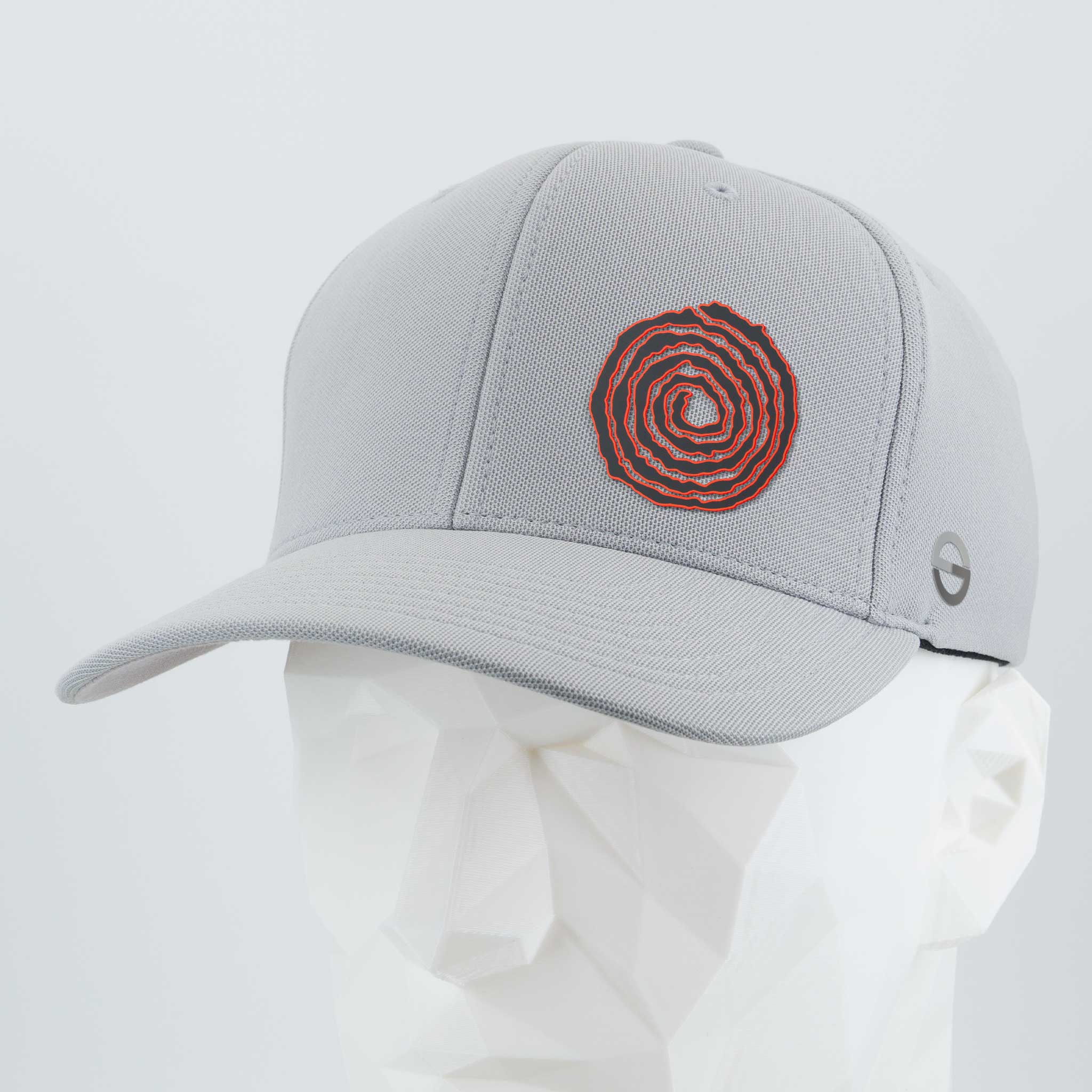 The Eternal Glyph Moab Spiral Petroglyph (Silicone) Flexfit® Cool & Dry Cap in silver features a red Spiral Petroglyph design on the front and a small gray side logo, shown on a faceted white mannequin head.