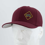 The Eternal Glyph Tortoise Crossing Sign (Silicone) Flexfit® Premium Wool Blend Cap, maroon with a yellow diamond turtle patch, is shown on a white geometric mannequin head against a plain gray background.