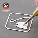 A hand peels an Eternal Glyph Fishing Trail Sign (Silicone) icon sticker from a gray surface. "TOUGH SILICONE GLYPH" appears next to a hexagonal logo, referencing the Flexfit® Mesh Trucker Cap by Eternal Glyph.