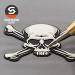 A gold pen points at a black and white silicone Pirate Skull & Crossbones patch by Eternal Glyph on gray fabric. “TOUGH SILICONE GLYPH” appears near the logo, accenting this modern Jolly Roger on a Flexfit® Cool & Dry Cap.
