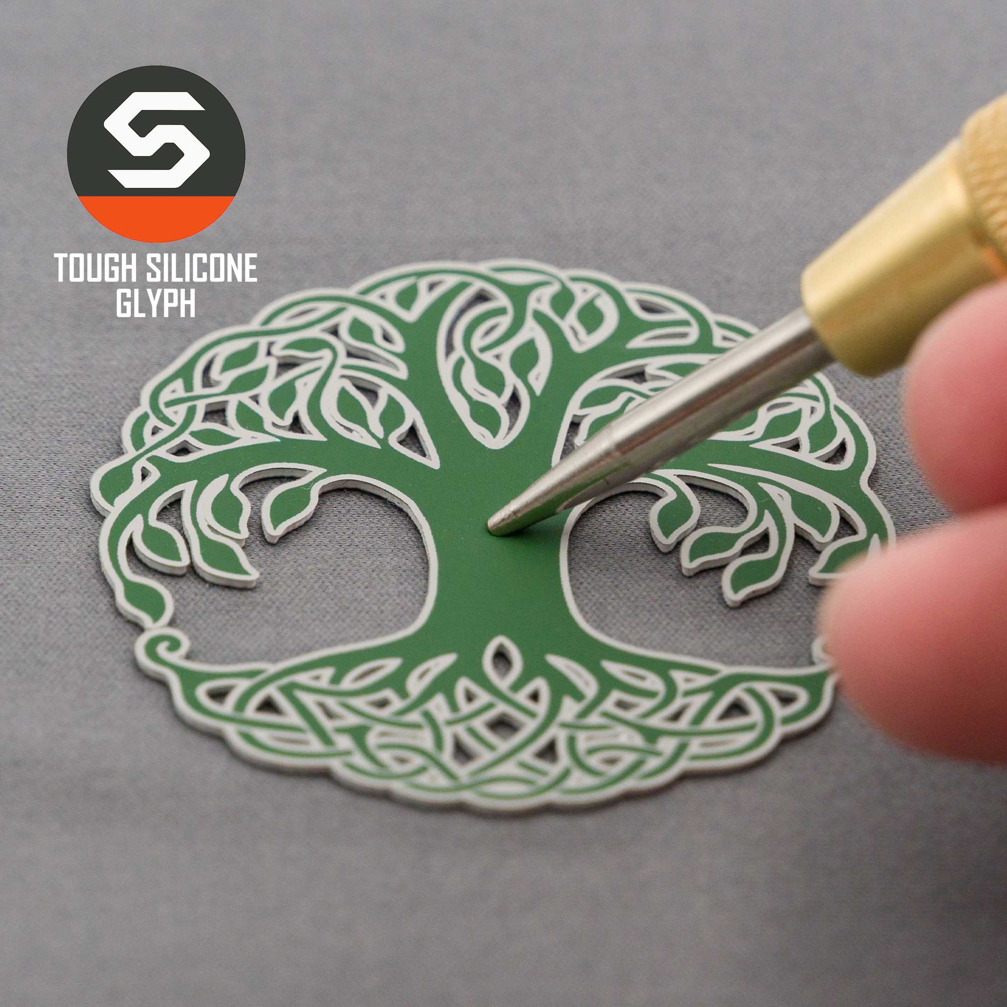 A hand holds a tool near a green silicone Tree of Life glyph, symbolizing growth. In the top left, “Eternal Glyph” and the Flexfit® Mesh Trucker Cap name appear beside a geometric logo.