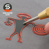 A hand holds a tool near a black and red Spiral Warrior Petroglyph (Silicone) figure with a spiral tail and wavy arms. The Eternal Glyph logo and "TOUGH SILICONE GLYPH" are shown beside a Flexfit® Mesh Trucker Cap.
