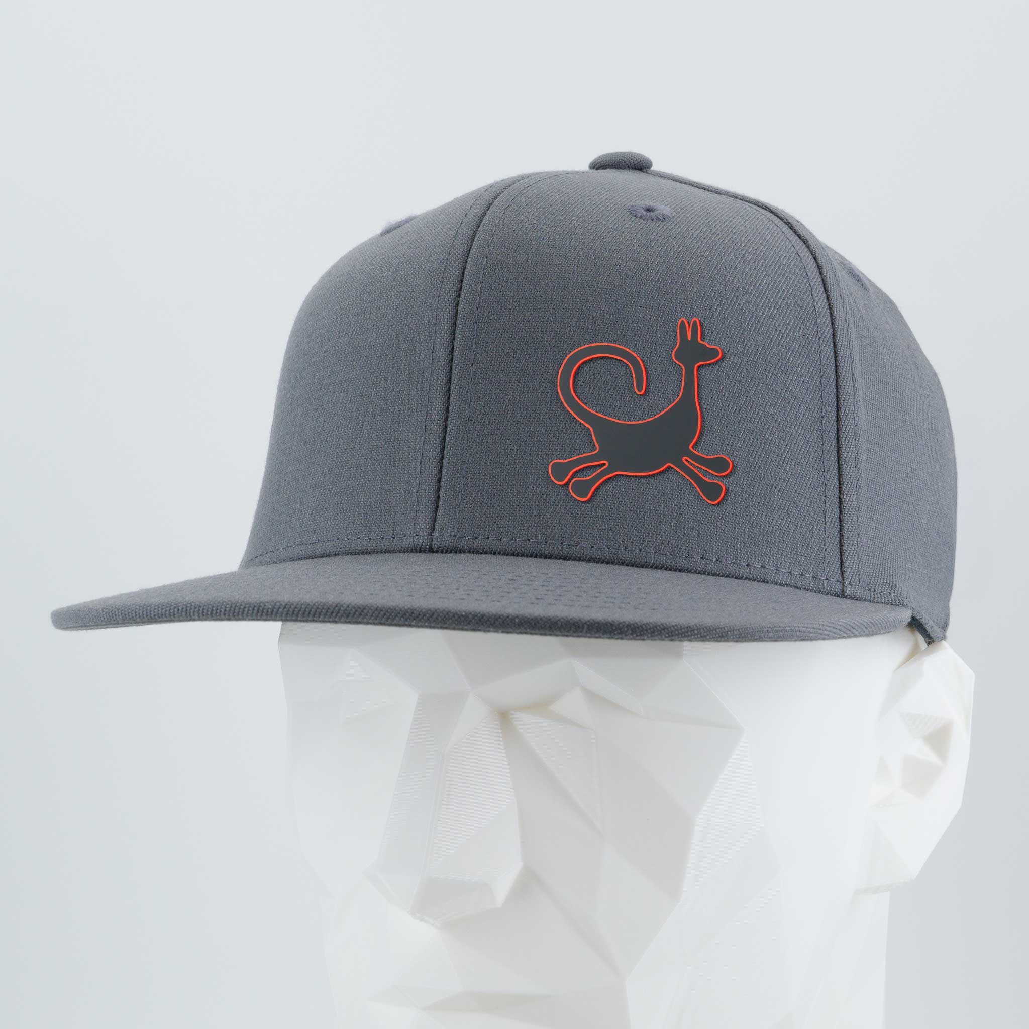The Eternal Glyph Moab Trickster, Coyote Petroglyph (Silicone) Flexfit® Flat Bill Premium Fitted Cap, in gray with a red kangaroo-like logo, is shown on a white mannequin head against a light gray background.