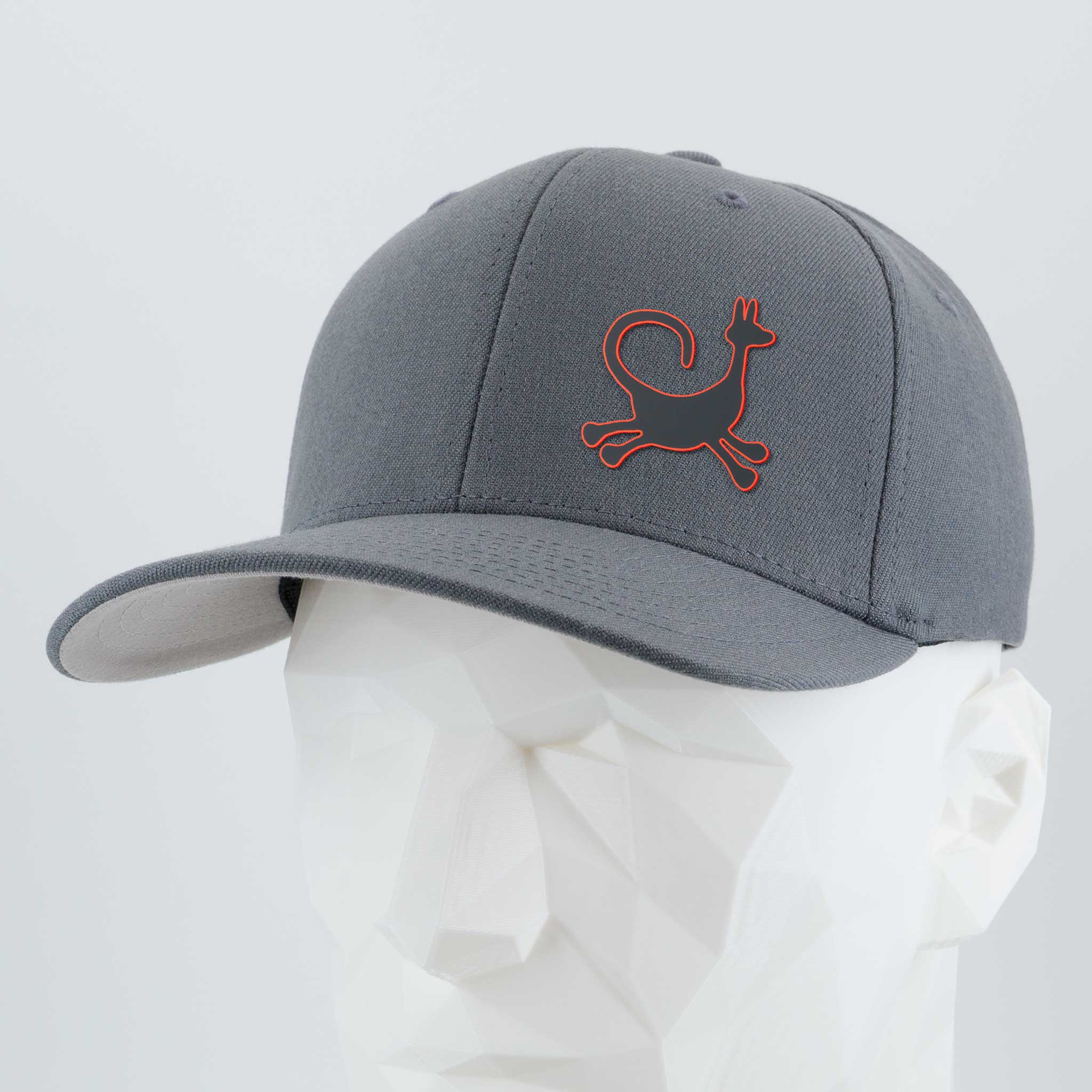 The Eternal Glyph Moab Trickster Flexfit® Cap features a red-outlined coyote petroglyph, inspired by Moab rock art, on gray premium wool blend—shown here on a white geometric mannequin head.