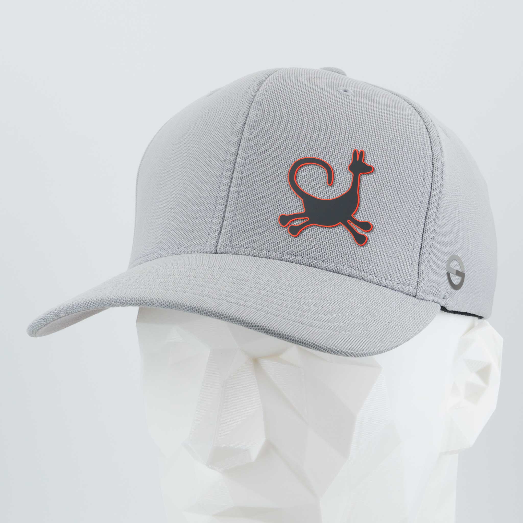 The Eternal Glyph Moab Trickster Flexfit® Cool & Dry Cap in silver features a stylized coyote petroglyph with red outline on the front and a small gray emblem on the side, inspired by Moab, Utah rock art. Displayed on a white mannequin head.