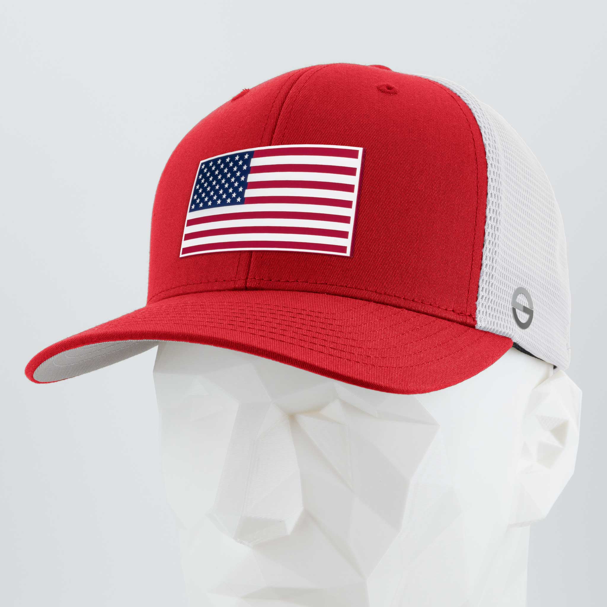 The Eternal Glyph American Flag Red/White Flexfit® Mesh Trucker Cap features double layer silicone, a mesh back, and an American flag patch, displayed on a white geometric mannequin head.