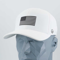 The Eternal Glyph Flexfit® Cool & Dry Cap in white features a double layer silicone monotone American flag patch, shown on a geometric gray mannequin head.